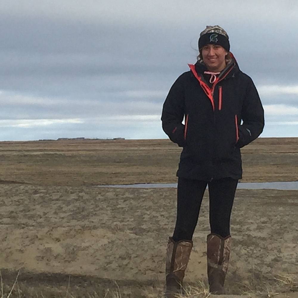 Katlyn stands and smiles in the tundra.